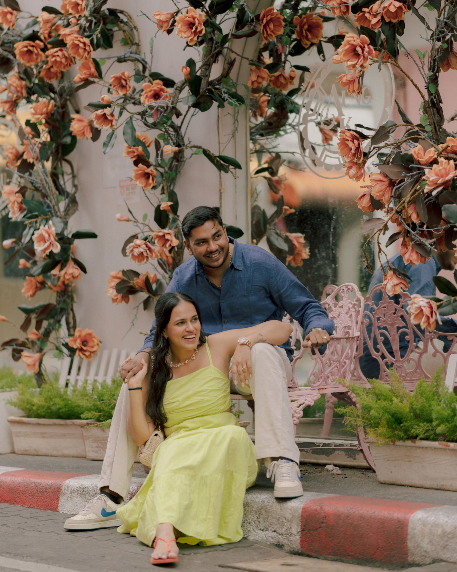 A couple relaxing together beneath an arch of flowers